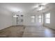 Spacious living room with wood-look floors, neutral paint, dining chandelier, and view of the patio doors at 45633 W Mountain View Rd, Maricopa, AZ 85139