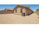 A gravel backyard featuring the exterior wall of the home, windows, and an air conditioning unit at 46123 W Sheridan Rd, Maricopa, AZ 85139