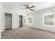 Bright bedroom with neutral carpet, closet, and plenty of natural light from multiple windows at 46123 W Sheridan Rd, Maricopa, AZ 85139