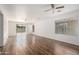 Spacious living room featuring wood floors, plenty of natural light, and ceiling fans at 46123 W Sheridan Rd, Maricopa, AZ 85139