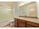 Bathroom with a vanity, granite countertop, and a shower-tub combo with sliding doors at 5215 W Onyx Ave, Glendale, AZ 85302