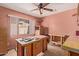 Bedroom with ceiling fan, desk, window, and peach colored walls at 5215 W Onyx Ave, Glendale, AZ 85302