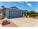 Exterior shot of house featuring a garage door with navy accents and desert landscaping at 5215 W Onyx Ave, Glendale, AZ 85302