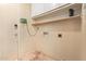 Utility room featuring a door, cabinets, shelf, and utility hookups at 5215 W Onyx Ave, Glendale, AZ 85302