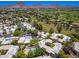 Aerial view overlooking a lush neighborhood with mature trees, manicured lawns, community pool, and mountain views at 5221 N 24Th St # 103, Phoenix, AZ 85016