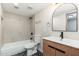 Bright bathroom featuring an elegant sink vanity, bathtub and shower combo, and a modern herringbone tile floor at 5221 N 24Th St # 103, Phoenix, AZ 85016