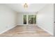 Bright, empty bedroom featuring modern wood flooring and black-framed windows with a view of the lush green outdoors at 5221 N 24Th St # 103, Phoenix, AZ 85016