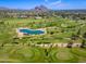 Aerial view of golf course with pond, manicured fairways and desert mountain backdrop at 5221 N 24Th St # 103, Phoenix, AZ 85016