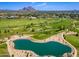 Aerial of manicured golf course with water hazard, desert landscaping and mountain backdrop at 5221 N 24Th St # 103, Phoenix, AZ 85016
