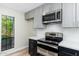 Modern kitchen with stainless steel appliances, sleek countertops, gray shaker cabinets and a window view at 5221 N 24Th St # 103, Phoenix, AZ 85016