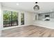 Bright living room featuring wood floors, a modern light fixture, and large windows with natural light at 5221 N 24Th St # 103, Phoenix, AZ 85016