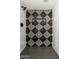 Modern shower showcasing geometric tile design, black fixtures, and a built-in shelf for toiletries at 5221 N 24Th St # 103, Phoenix, AZ 85016