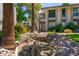 Stunning building exterior featuring a tranquil waterfall, mature palms, and decorative rock details at 5221 N 24Th St # 103, Phoenix, AZ 85016