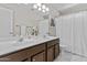 Bathroom featuring double sinks, brown wood cabinets, and white marble floors at 5423 W Michigan Ave, Glendale, AZ 85308