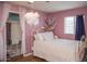 This bedroom has a white bed frame with pink walls and a white cloud hanging from the ceiling at 546 S Ellsworth Rd, Mesa, AZ 85208