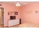 Cozy bedroom with light pink walls, ceiling fan and a dresser and TV with a decorative name sign at 546 S Ellsworth Rd, Mesa, AZ 85208