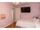 Cozy bedroom features a comfortable bed, a flat screen tv, and is painted in pink at 546 S Ellsworth Rd, Mesa, AZ 85208