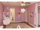 Cozy bedroom featuring a hammock chair, unique lighting, and soft carpet with pink walls at 546 S Ellsworth Rd, Mesa, AZ 85208