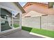 Enclosed backyard with artificial grass and a window view into the home at 7204 W Mcrae Way, Glendale, AZ 85308