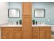 Bathroom featuring double sinks, granite countertops, wood cabinets and modern fixtures at 7204 W Mcrae Way, Glendale, AZ 85308