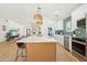 Open-concept kitchen with a large island, stainless steel appliances, and pendant lighting at 7204 W Mcrae Way, Glendale, AZ 85308