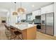 Open-concept kitchen featuring a large island with marble countertop and breakfast bar seating at 7204 W Mcrae Way, Glendale, AZ 85308