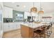 Modern kitchen with an island, pendant lighting, white cabinets and stainless steel appliances at 7204 W Mcrae Way, Glendale, AZ 85308
