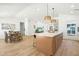 Open kitchen featuring a kitchen island, modern lighting, and stainless steel appliances at 7204 W Mcrae Way, Glendale, AZ 85308