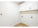 Clean laundry area showcasing wall mounted cabinets with washer and dryer hookups at 7204 W Mcrae Way, Glendale, AZ 85308