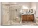 Bathroom featuring a walk-in shower with bench and glass door, with wooden vanity at 7804 S 15Th Ave, Phoenix, AZ 85041