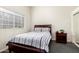Bright bedroom with wood floors, a full sized bed and dark wood bedside table at 7804 S 15Th Ave, Phoenix, AZ 85041