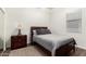 Cozy bedroom with wood floors, a queen bed and dark wood bedside table at 7804 S 15Th Ave, Phoenix, AZ 85041