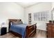 Cozy bedroom with wood floors, a full sized bed and dark wood bedside table at 7804 S 15Th Ave, Phoenix, AZ 85041