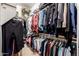 Walk-in closet with many hanging clothes, overhead storage and built in shelves at 7804 S 15Th Ave, Phoenix, AZ 85041