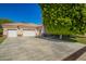 Exterior shot with a three-car garage and spacious driveway surrounded by mature landscaping at 7804 S 15Th Ave, Phoenix, AZ 85041