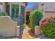 Inviting walkway with a wrought iron gate, red brick pathway, and mature landscaping at 7955 E Chaparral Rd # 73, Scottsdale, AZ 85250