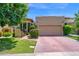 Beautiful home featuring a brick driveway, mature landscaping, and an attached two-car garage at 7955 E Chaparral Rd # 73, Scottsdale, AZ 85250
