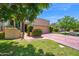Charming home featuring a brick driveway, beautiful landscaping, and a lush green lawn at 7955 E Chaparral Rd # 73, Scottsdale, AZ 85250