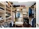 Spacious walk-in closet with custom shelving, ample storage, and a built-in wine fridge at 7955 E Chaparral Rd # 73, Scottsdale, AZ 85250