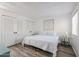 Inviting bedroom with white bedding, wood-look floors, complemented by stylish side tables and neutral decor at 8055 E Thomas Rd # 104, Scottsdale, AZ 85251