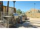 Outdoor grill area featuring stone countertops, modern appliances, and community seating for entertaining guests at 8055 E Thomas Rd # 104, Scottsdale, AZ 85251