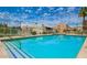 Inviting community pool with clear blue water, lounge chairs, umbrellas, and well-maintained landscaping at 8055 E Thomas Rd # 104, Scottsdale, AZ 85251