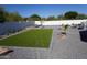 Spacious backyard featuring artificial turf, desert landscaping, and a white privacy fence at 8156 E Questa Rd, Scottsdale, AZ 85255