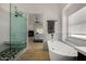 Bathroom featuring a modern glass shower, soaking tub, and a glimpse of a bedroom with fireplace at 8156 E Questa Rd, Scottsdale, AZ 85255