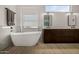 Bright bathroom featuring a soaking tub, dual vanity, modern fixtures, and large bright window at 8156 E Questa Rd, Scottsdale, AZ 85255