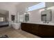 Bright bathroom featuring a soaking tub, dual vanity with modern fixtures, and a view to a bedroom at 8156 E Questa Rd, Scottsdale, AZ 85255