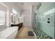 Bright bathroom featuring double sink vanity, soaking tub, and walk-in shower with designer finishes at 8156 E Questa Rd, Scottsdale, AZ 85255