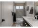 Bathroom with modern vanity, matte black hardware, white countertops, and a window with shades at 8156 E Questa Rd, Scottsdale, AZ 85255