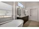 Bright bathroom featuring a soaking tub, dual vanity with modern fixtures, and a bright window at 8156 E Questa Rd, Scottsdale, AZ 85255