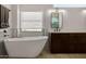 Soaking tub beneath a window, featuring white marble tile and black fixtures, giving a spa-like feel at 8156 E Questa Rd, Scottsdale, AZ 85255